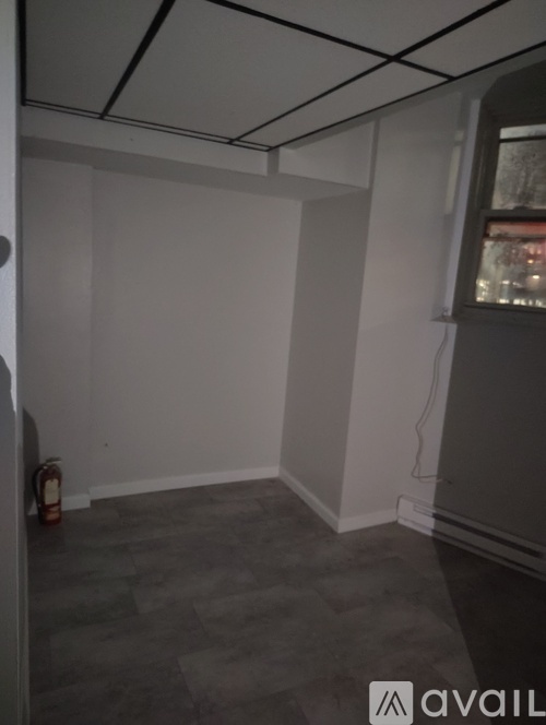 A room with grey carpet and white walls.