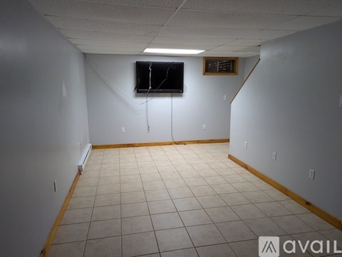 A room with a television and a wooden floor.