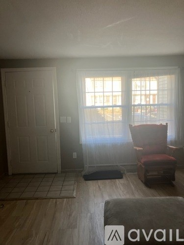 A room with a chair and a door.
