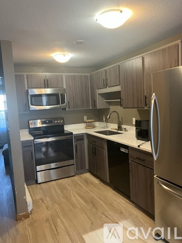 A kitchen with a stainless steel refrigerator, oven, and microwave.