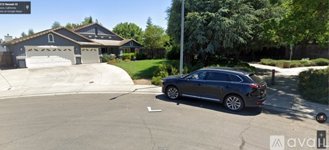 A grey car is parked in a driveway.