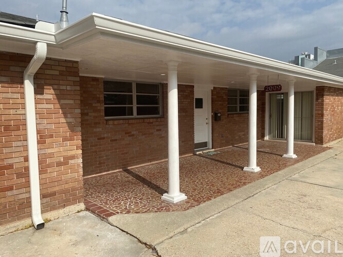 A building with a white roof and pillars with a sign that says "2051" on it.