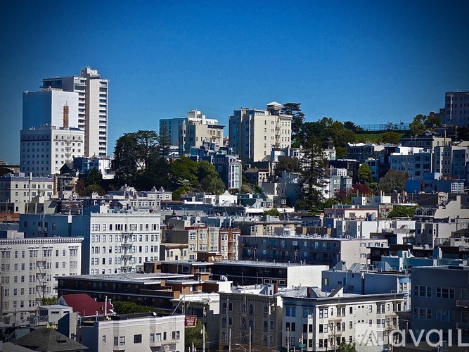A cityscape with various buildings and a clear blue sky.