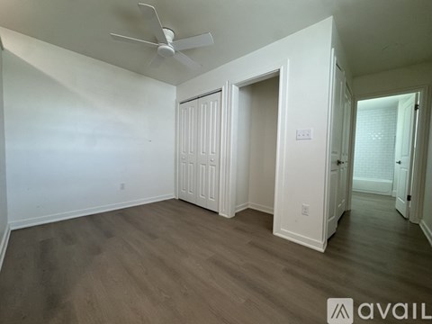 A room with a ceiling fan and wooden flooring.