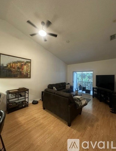 A living room with a couch, a chair, and a television.