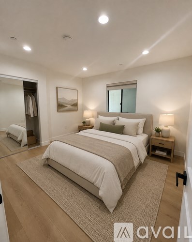 A bedroom with a large bed and a painting on the wall.