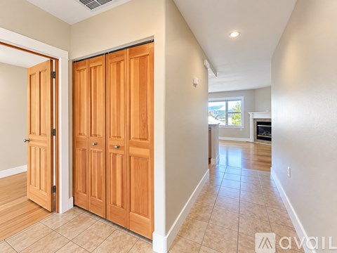 A spacious room with a carpeted floor and two windows.