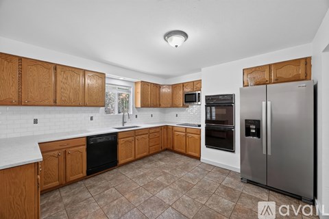 A kitchen with wooden cabinets and a tiled backsplash.