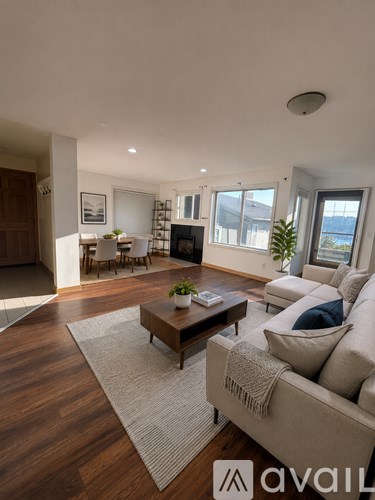 A living room with a couch, coffee table, and a large window.