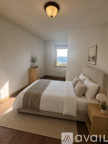 A bedroom with a large bed and a window overlooking the water.