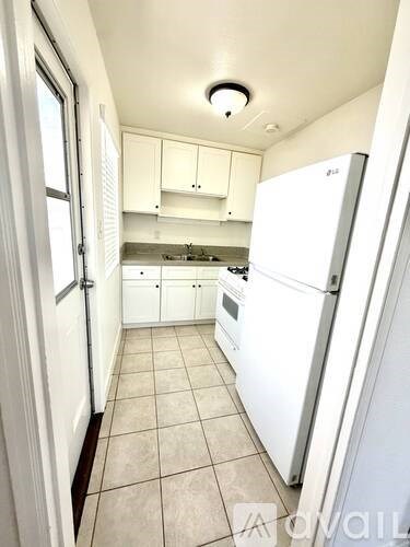 A kitchen with white appliances and cabinets.