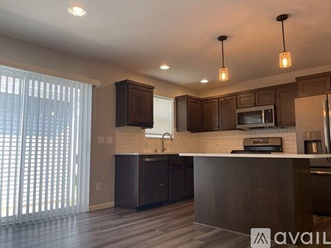 A modern kitchen with dark wood cabinets and a central island.