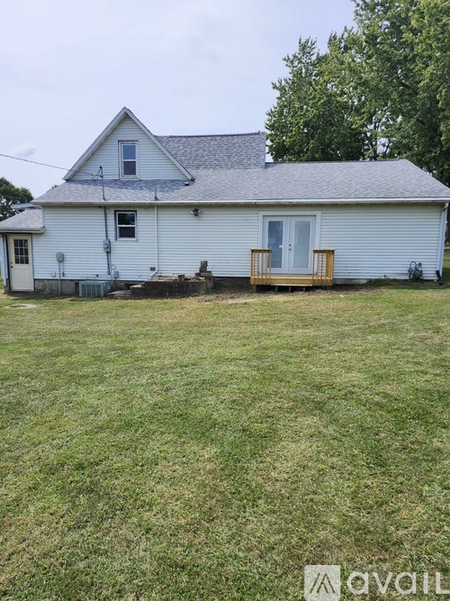 A white house with a grey roof and a small porch.