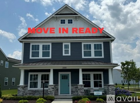 A house with a sign that says "Move in Ready" in front of it.