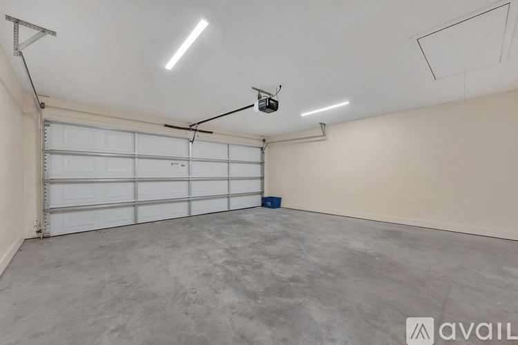 A spacious garage with a white door and a ceiling fan.