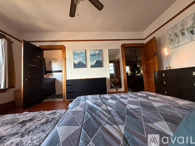 A bedroom with a large bed and a ceiling fan.