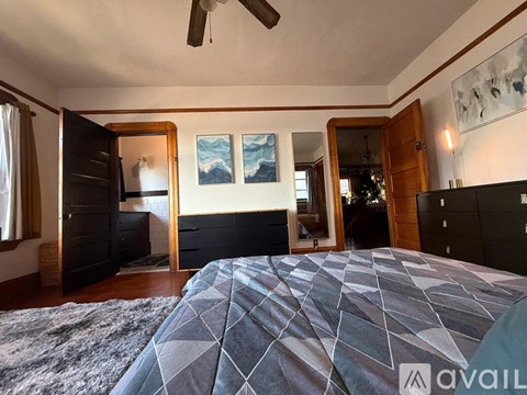 A bedroom with a large bed and a ceiling fan.