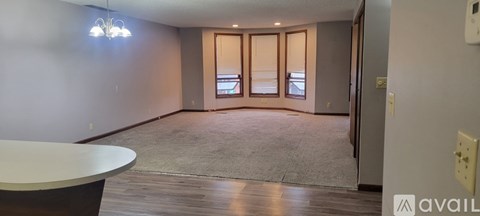 A room with a round table and a carpet on the floor.