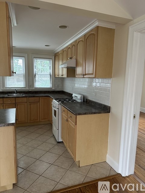 A kitchen with wooden cabinets and a black countertop.