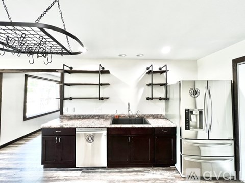 A modern kitchen with dark wood cabinets and a white fridge.