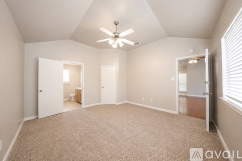 A spacious room with a carpeted floor and a ceiling fan.