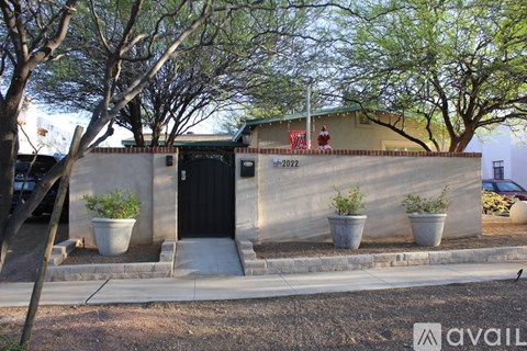 A building with a black door and a red sign on the wall.