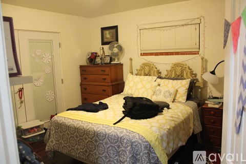 A bedroom with a bed, dresser, and a mirror.