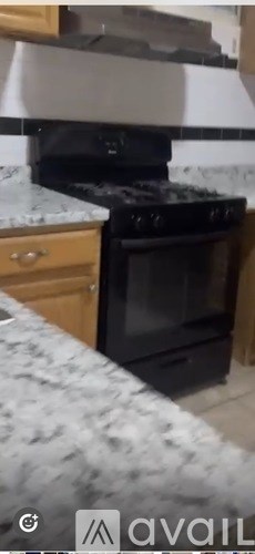 A black oven is installed in a kitchen with a granite countertop.