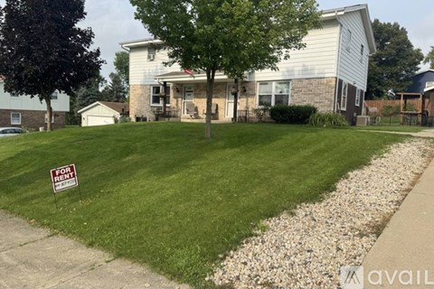 A house with a "For Sale" sign in front of it.