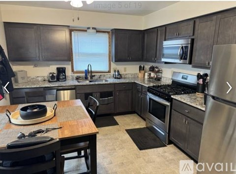 A kitchen with a table and chairs in front of a stove and oven.