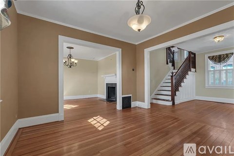 A living room with a fireplace and a staircase.