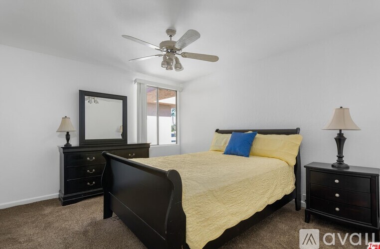 A bedroom with a bed, dresser, and mirror.