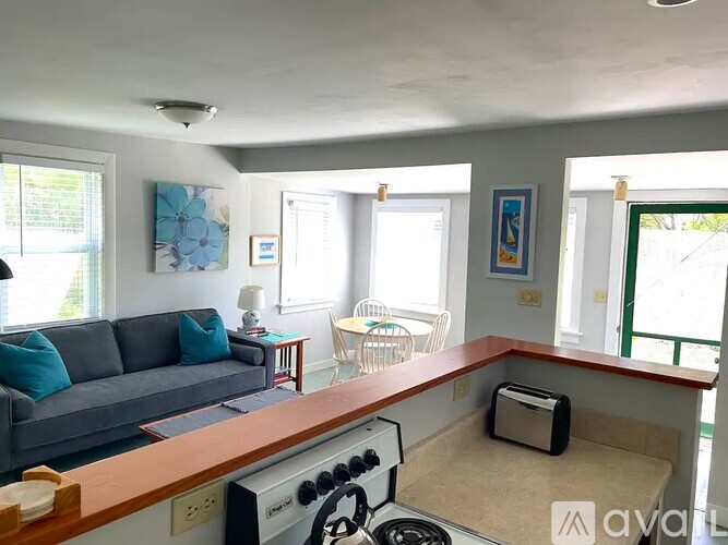 A kitchen with a stove top oven and a couch.