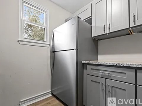 A kitchen with a stainless steel refrigerator and cabinets.