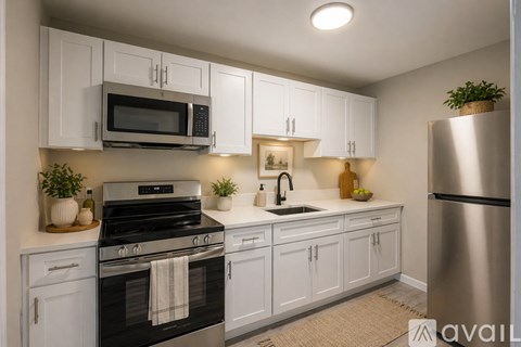 A kitchen with white cabinets and a black stove top oven.