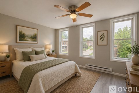 A bedroom with a large bed and a ceiling fan.