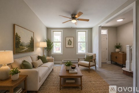 A living room with a couch, chair, and a painting on the wall.