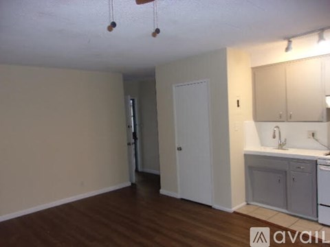 A kitchen area with a sink, cabinets, and a door.