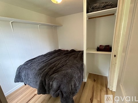 A bedroom with a bed and a shelf.