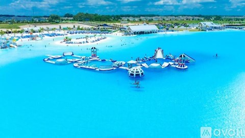 A large, open water park with a blue pool and a white water slide.