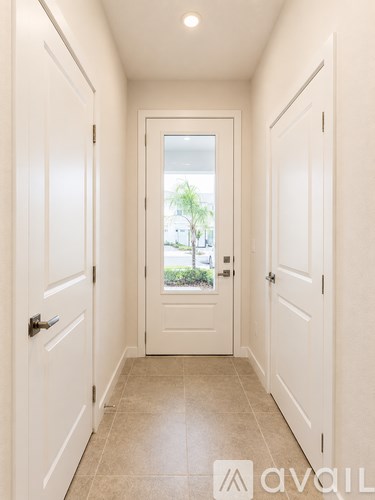 A hallway with white doors and a tiled floor.
