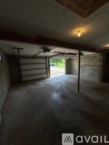 A garage with a door open and a light on.