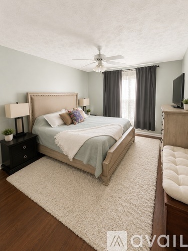 A bedroom with a large bed and a ceiling fan.