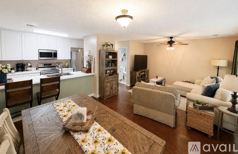 A well-lit, spacious living room and kitchen area with modern appliances and furniture.
