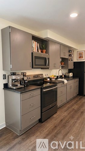 A modern kitchen with a stainless steel refrigerator and a microwave above the stove.