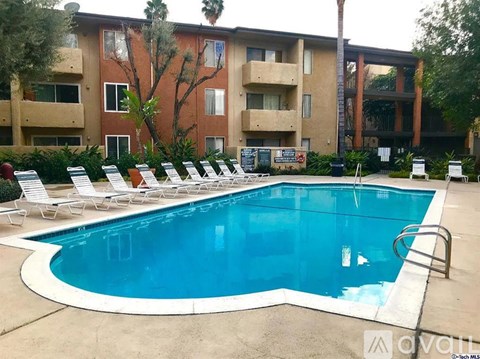 A swimming pool in front of a building with a sign that says "Avail".