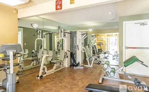 A gym with a variety of equipment including weights and machines.