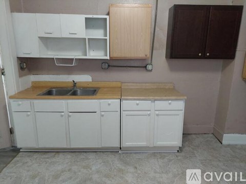 A kitchen with white cabinets and a wooden countertop.