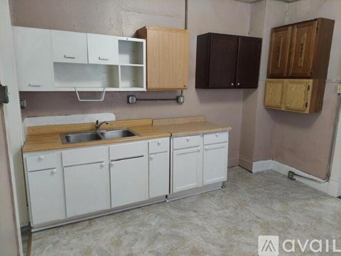 A kitchen with white cabinets and a wooden countertop.