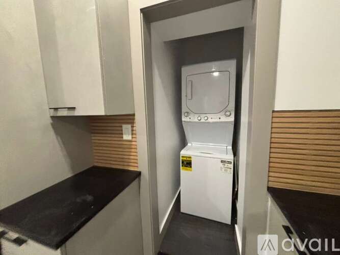 A white dishwasher is in a kitchen with a black counter.